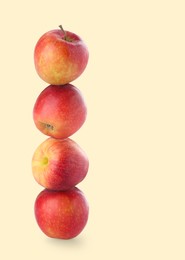 Image of Apples stacked on top of each other against beige background. Balance