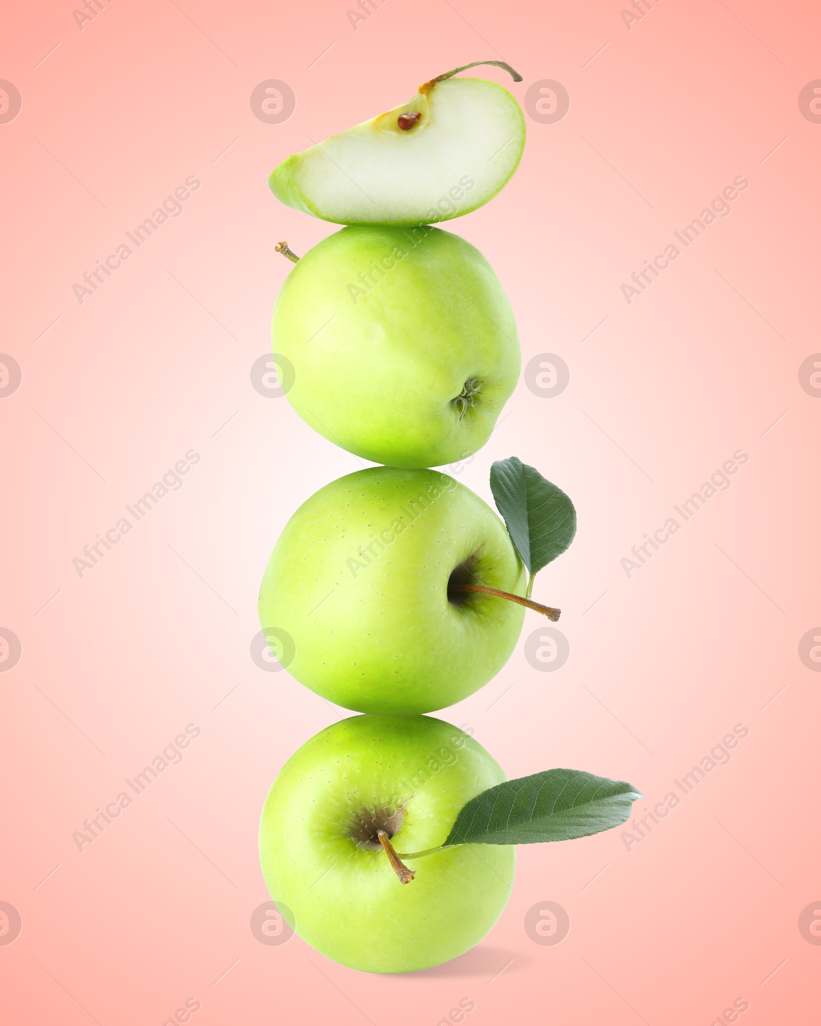 Green apples stacked on top of each other against pink gradient background. Balance Image of Green apples stacked on top of each other against pink gradient background. Balance