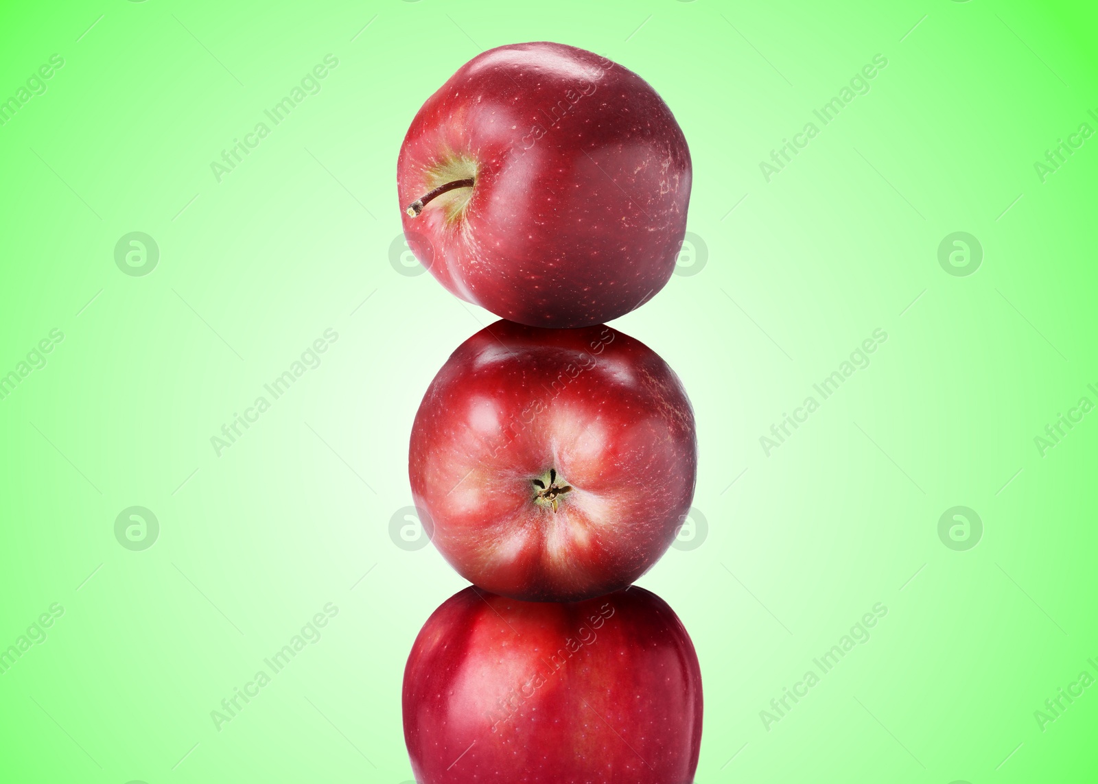 Red apples stacked on top of each other against green gradient background. Balance Image of Red apples stacked on top of each other against green gradient background. Balance