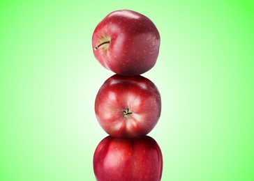Image of Red apples stacked on top of each other against green gradient background. Balance