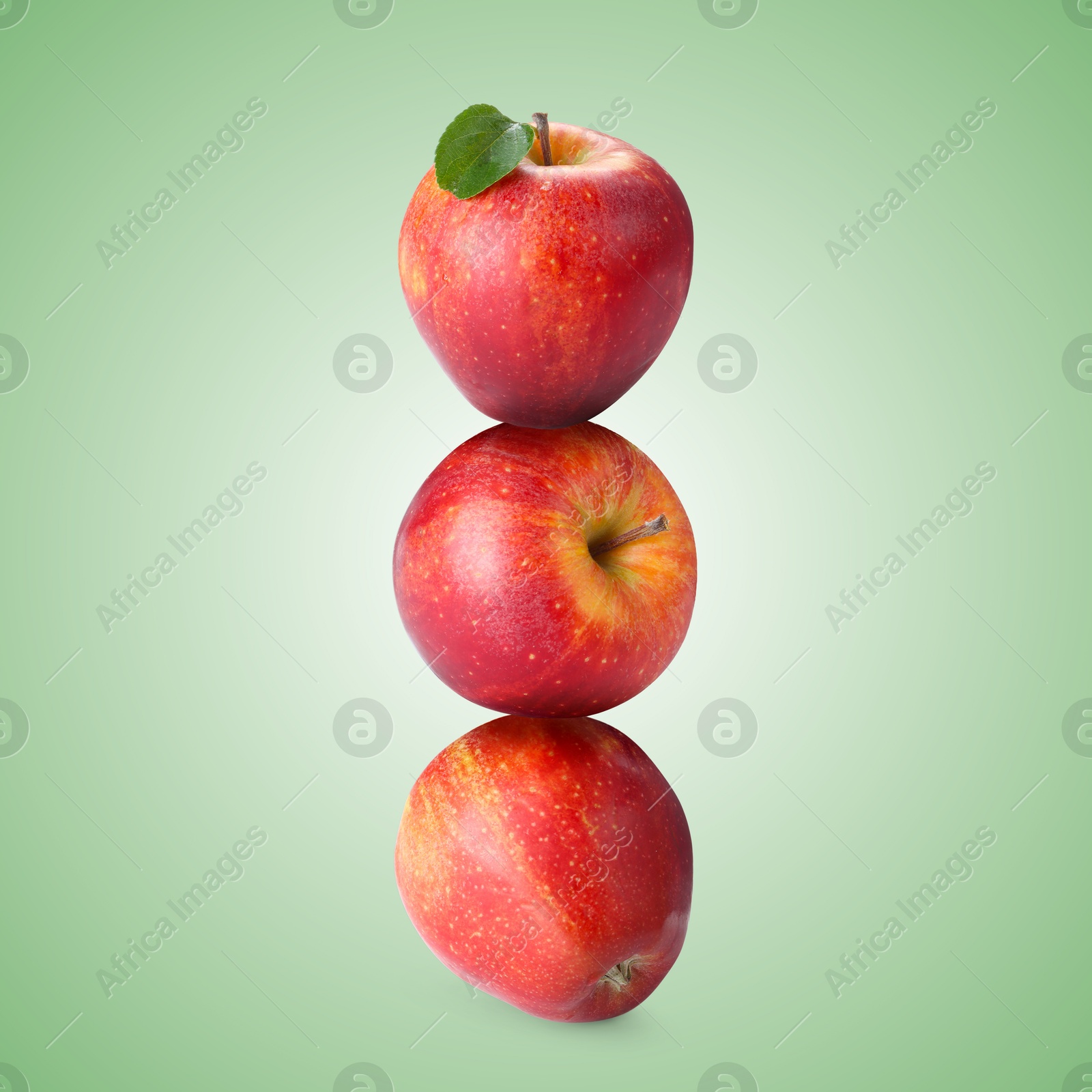 Red apples stacked on top of each other against pastel green background. Balance Image of Red apples stacked on top of each other against pastel green background. Balance