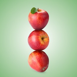 Image of Red apples stacked on top of each other against pastel green background. Balance