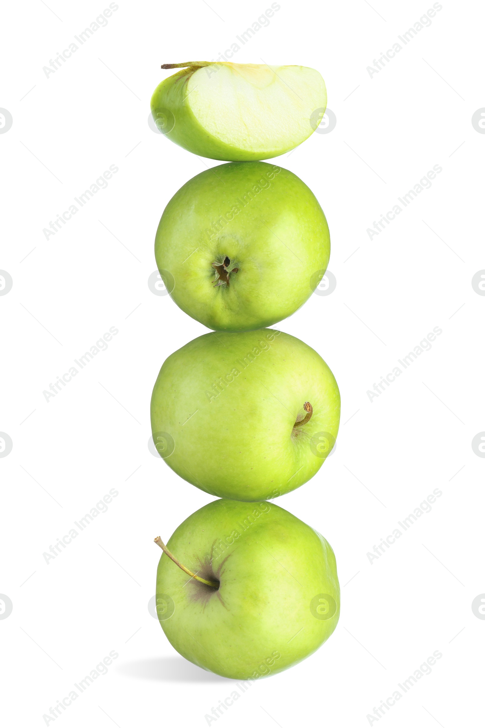 Image of Green apples stacked on top of each other against white background. Balance
