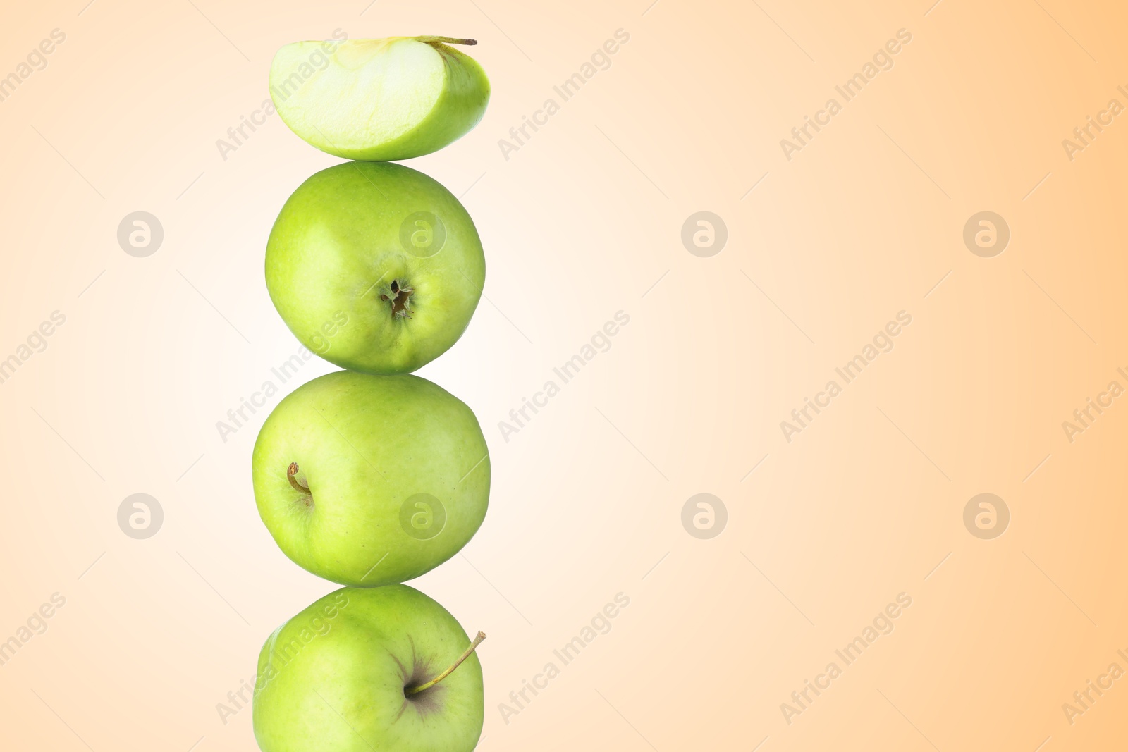 Green apples stacked on top of each other against beige gradient background. Balance Image of Green apples stacked on top of each other against beige gradient background. Balance