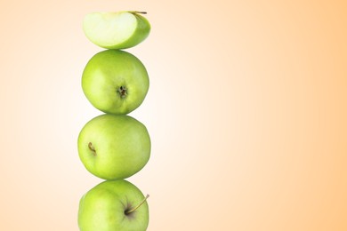 Image of Green apples stacked on top of each other against beige gradient background. Balance