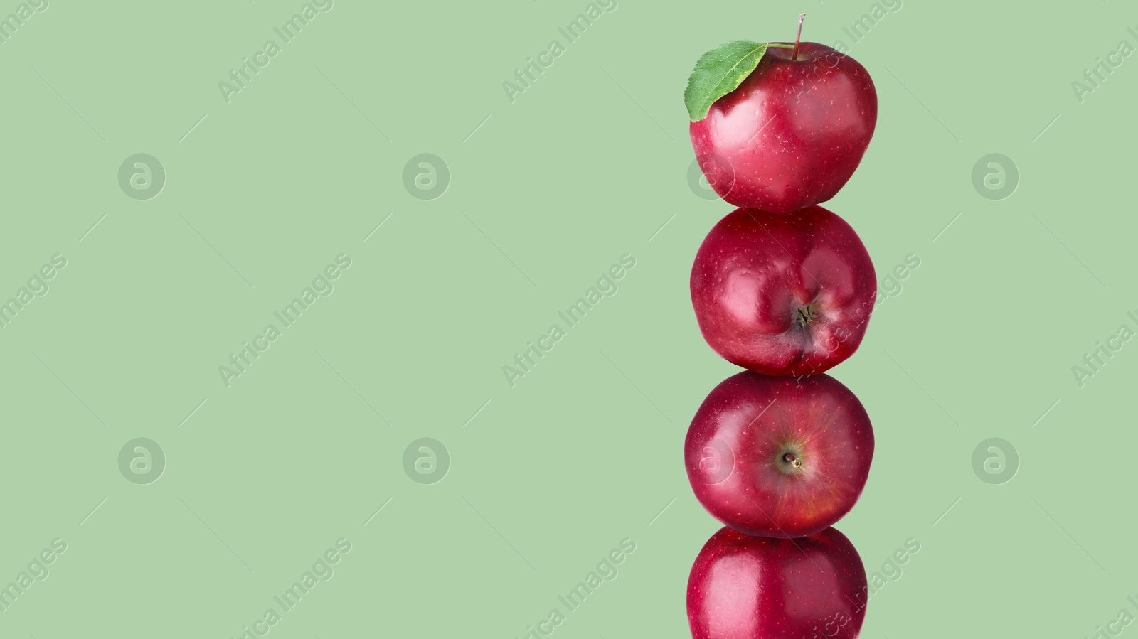 Red apples stacked on top of each other against sage color background. Balance Image of Red apples stacked on top of each other against sage color background. Balance