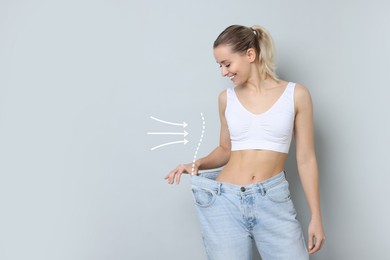 Image of Slim woman with perfect body in oversized jeans on grey background. Outline of previous overweight figure around. Result of healthy lifestyle