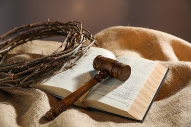 Photo of Judge's gavel, Bible and crown of thorns on burlap fabric