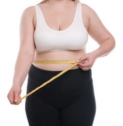 Photo of Weight loss. Plus size woman measuring waist with tape on white background, closeup