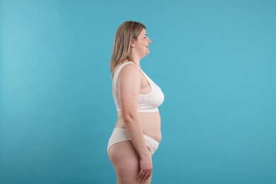 Photo of Weight loss. Plus size woman in underwear on light blue background
