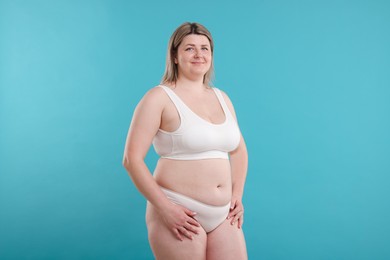Photo of Weight loss. Plus size woman in underwear on light blue background