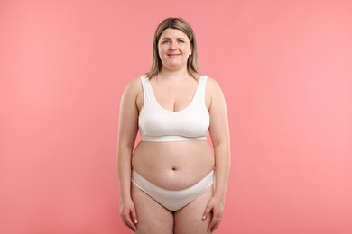 Photo of Weight loss. Plus size woman in underwear on pink background