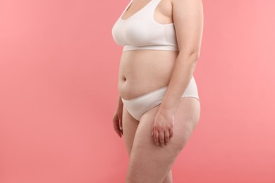 Photo of Weight loss. Plus size woman in underwear on pink background, closeup