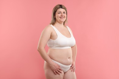Photo of Weight loss. Plus size woman in underwear on pink background