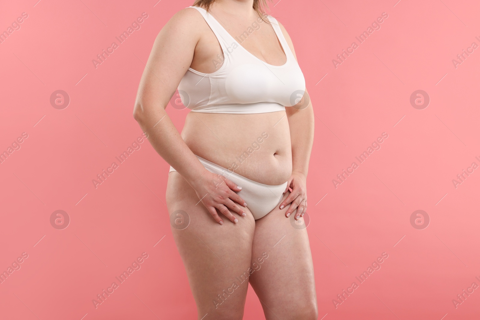 Weight loss. Plus size woman in underwear on pink background, closeup Photo of Weight loss. Plus size woman in underwear on pink background, closeup