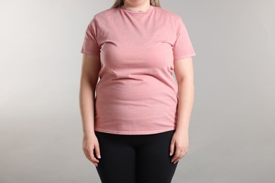 Photo of Weight loss. Plus size woman on gray background, closeup