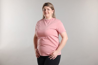 Photo of Weight loss. Plus size woman on gray background