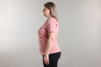 Photo of Weight loss. Plus size woman on gray background