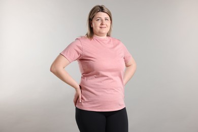 Photo of Weight loss. Plus size woman on gray background
