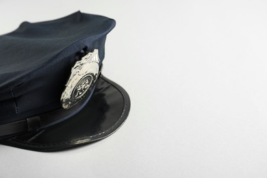 Photo of One police cap on white background, closeup. Space for text