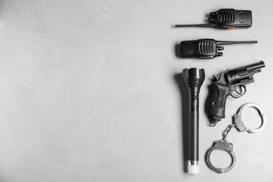 Photo of Different police equipment on light grey table, flat lay. Space for text