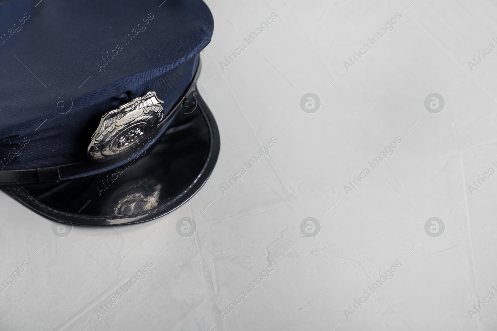 Photo of Police cap on light grey table, above view. Space for text