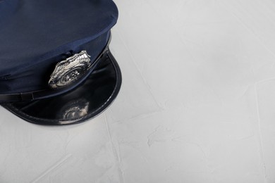 Photo of Police cap on light grey table, above view. Space for text