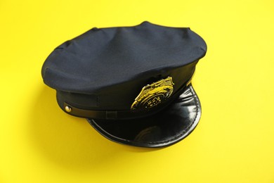 Photo of Police cap on yellow background, above view