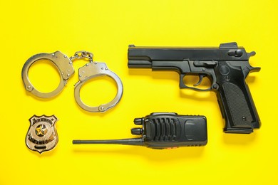 Photo of Different police equipment on yellow background, flat lay