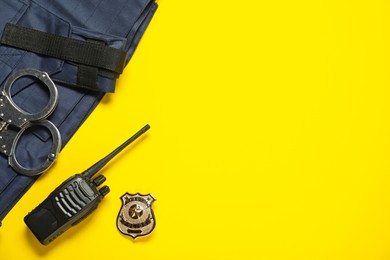 Photo of Different police equipment on yellow background, flat lay. Space for text