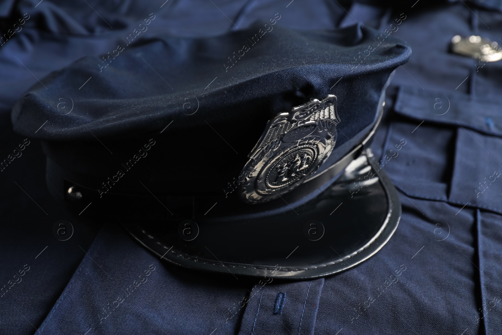 Police cap on dark blue uniform, closeup Photo of Police cap on dark blue uniform, closeup
