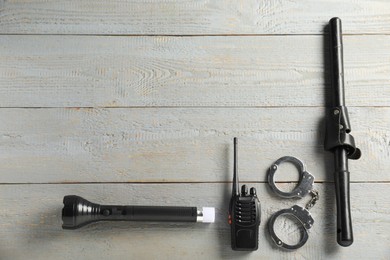 Photo of Different police equipment on grey wooden table, flat lay. Space for text