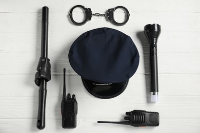 Photo of Different police equipment on white wooden table, flat lay