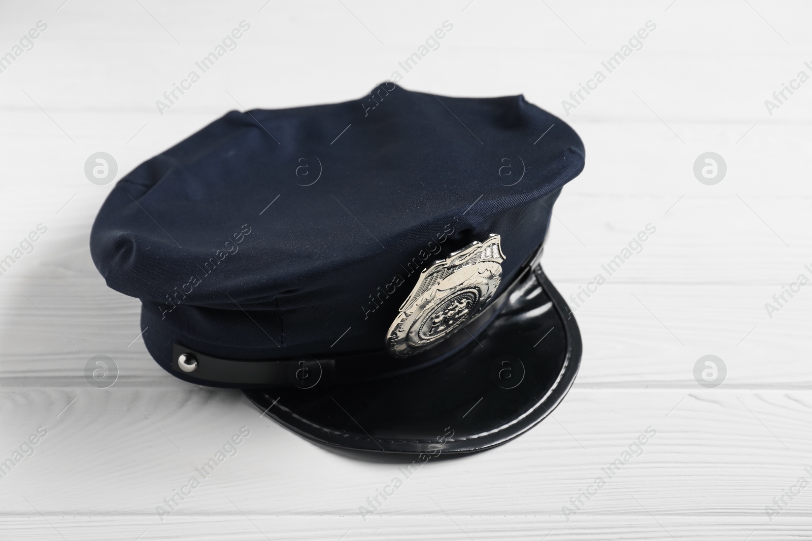 Police cap on white wooden table, closeup Photo of Police cap on white wooden table, closeup