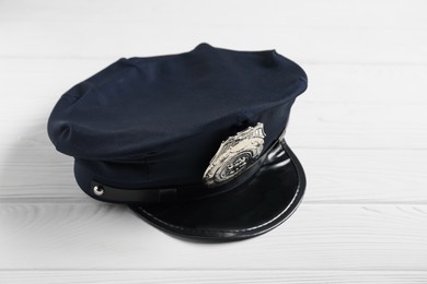 Photo of Police cap on white wooden table, closeup