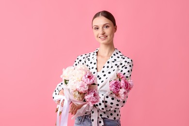 Photo of Woman with beautiful bouquets of peonies on pink background
