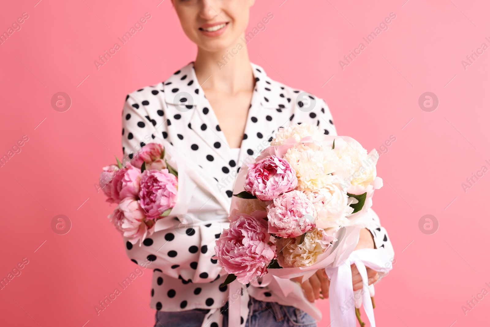 Woman with beautiful bouquets of peonies on pink background, closeup Photo of Woman with beautiful bouquets of peonies on pink background, closeup