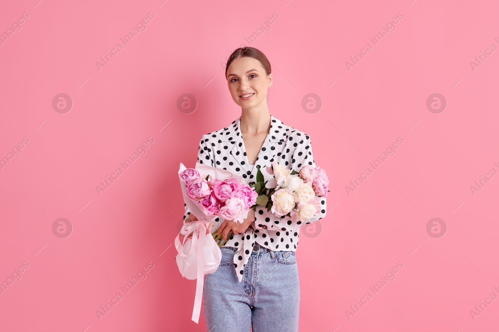 Woman with beautiful bouquets of peonies on pink background Photo of Woman with beautiful bouquets of peonies on pink background
