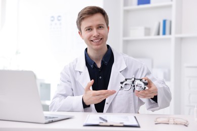 Photo of Portrait of professional ophthalmologist with trial frame at white table in clinic