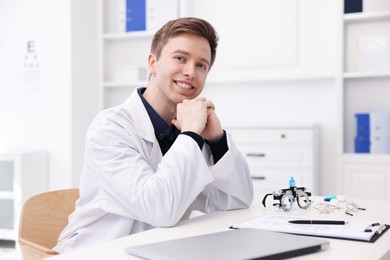 Photo of Portrait of professional ophthalmologist at white table in clinic