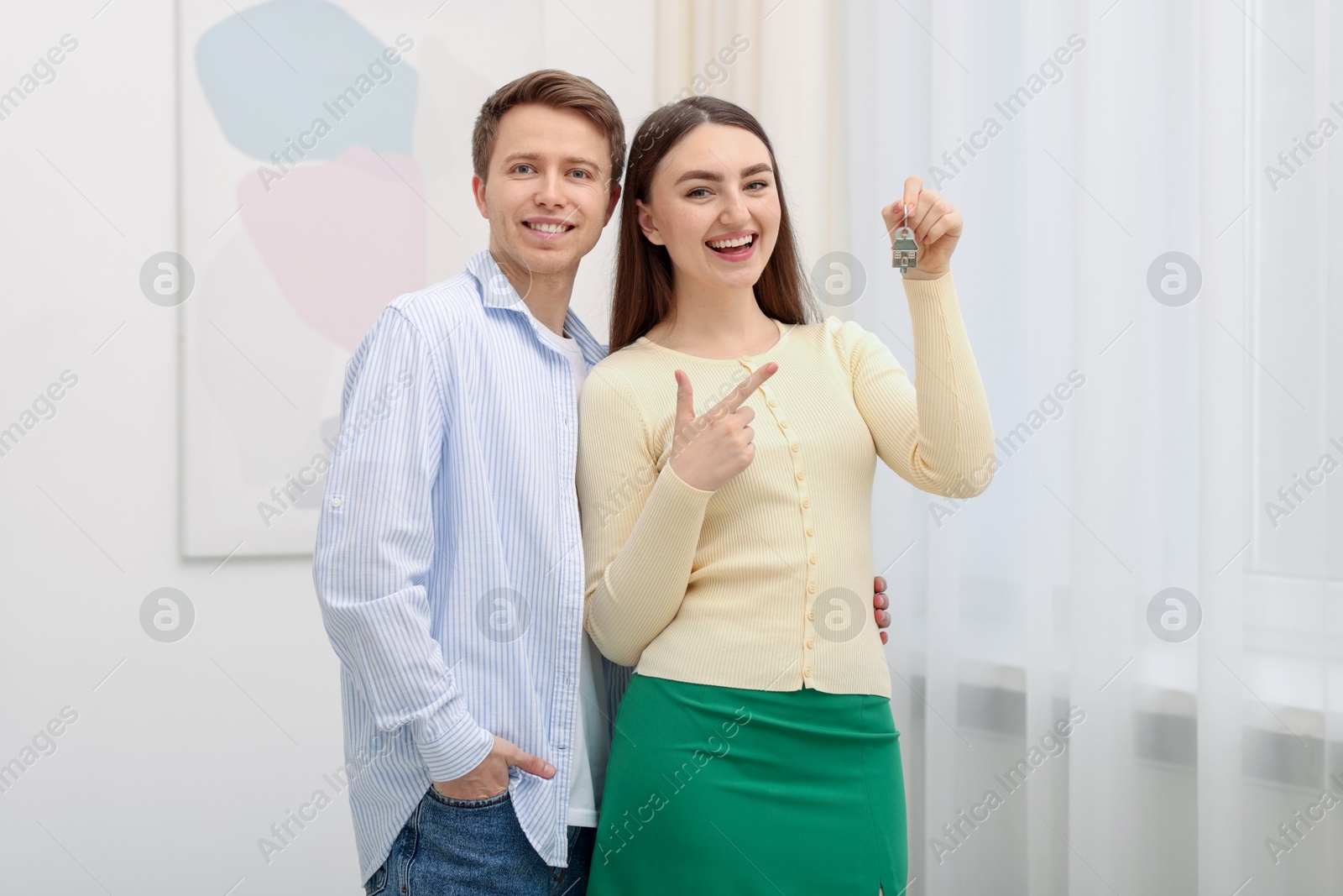 Happy couple with key of their new house indoors Photo of Happy couple with key of their new house indoors