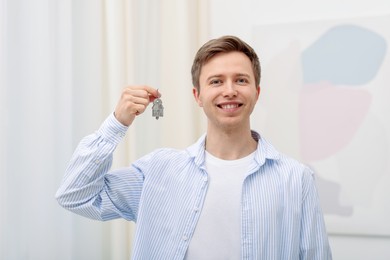 Photo of Happy man with house keys at home