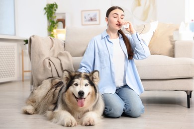 Photo of Woman suffering from allergy with her dog at home