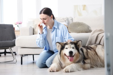 Photo of Woman suffering from allergy with her dog at home