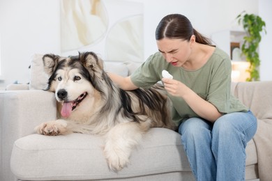 Photo of Woman suffering from allergy with her dog at home