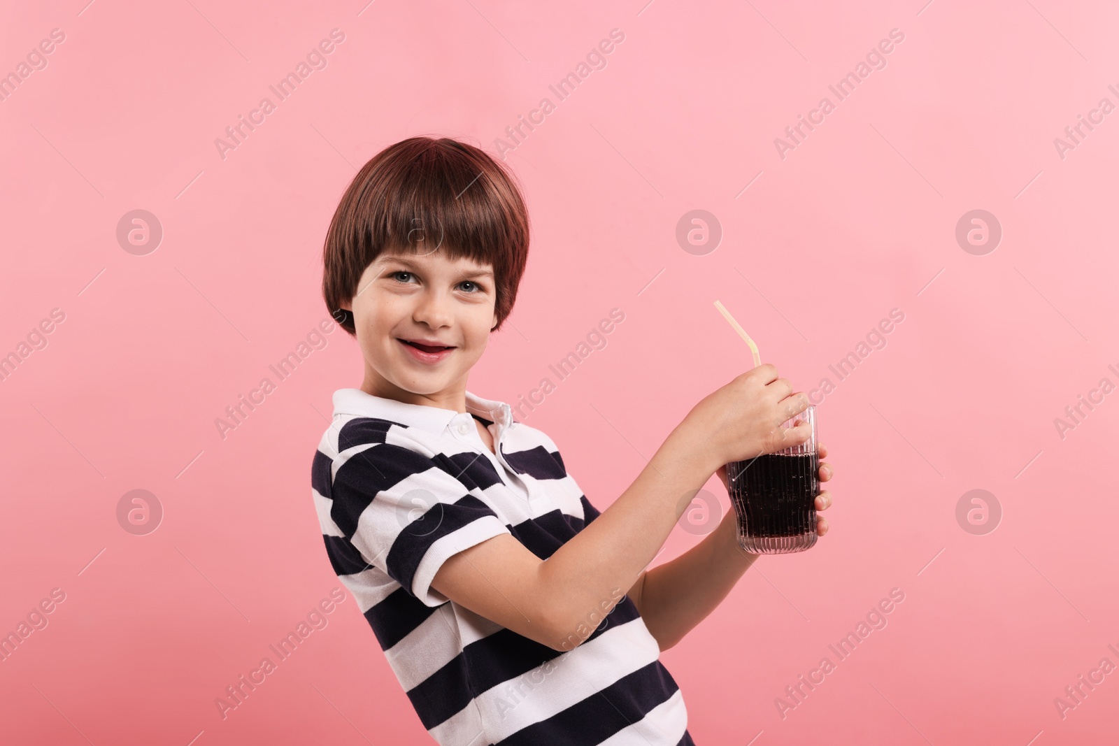 Cute little boy with glass of refreshing soda drink on pink background Photo of Cute little boy with glass of refreshing soda drink on pink background