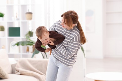 Photo of Happy mother playing with her son at home