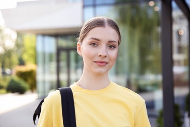 Photo of Teenage girl with backpack near building outdoors