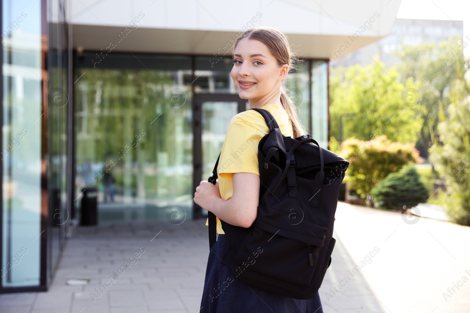 Teenage girl with backpack near building outdoors Photo of Teenage girl with backpack near building outdoors