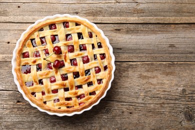 Photo of Tasty cherry pie on wooden table, top view. Space for text
